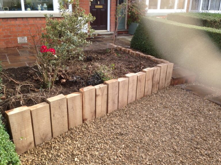 Garden with raised wooden border and pebbled ground.