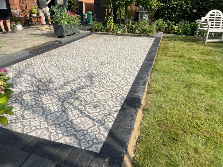 Garden with tiled patio and grass lawn.