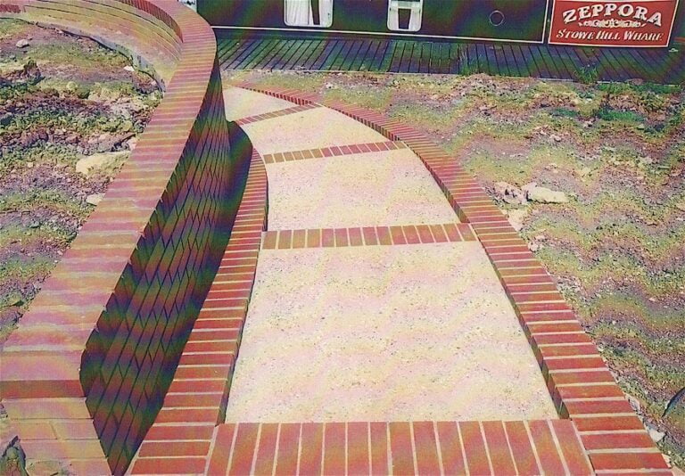 Brick border garden path near Zeppora sign.