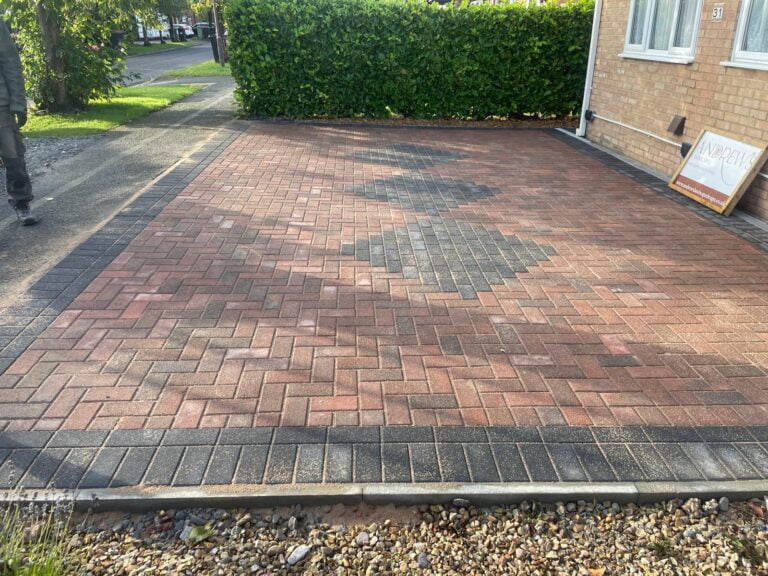 Newly laid brick driveway by house with garden.