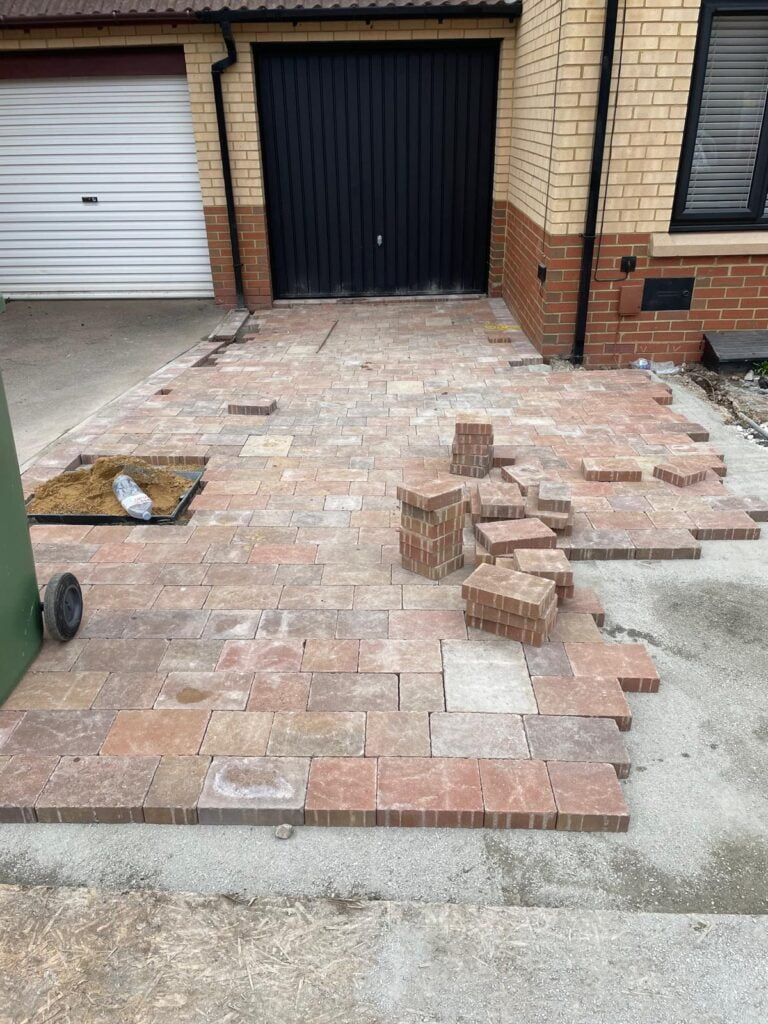 Brick driveway under construction outside house
