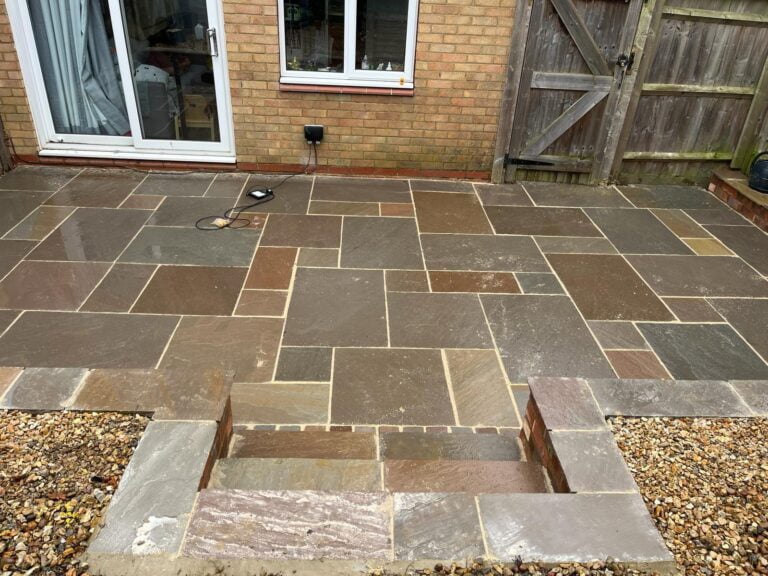Newly laid stone patio outside a house.